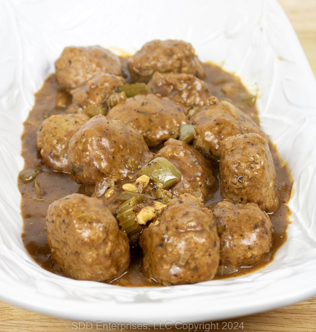 Cajun meatballs with gravy on a white serving platter.