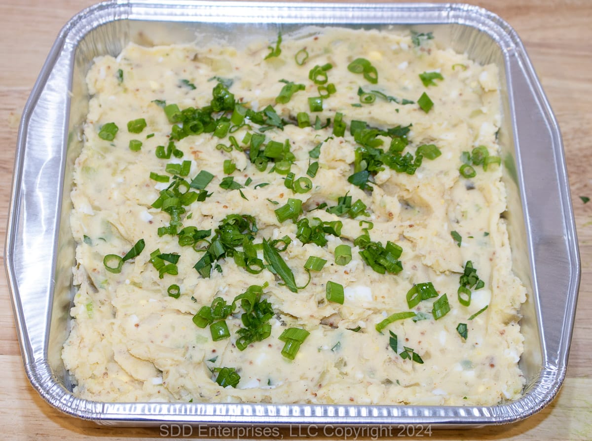 Cajun Potato Salad in a disposable serving bowl.