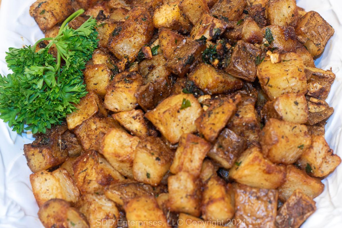 Brabant Potatoes on a white serving platter with garnish.