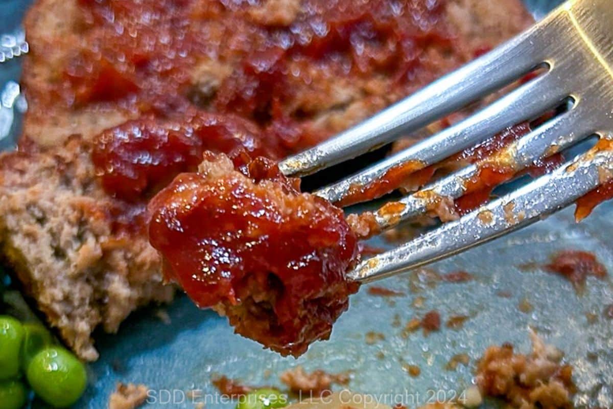 A bite of meatloaf on a fork.