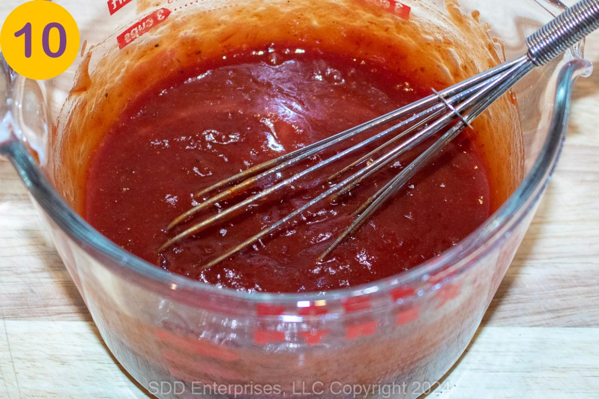 Sauce for meatloaf in a large glass measuring cup.