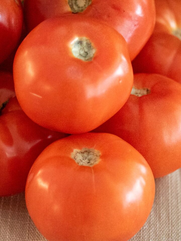Several fresh tomatoes on a counter.