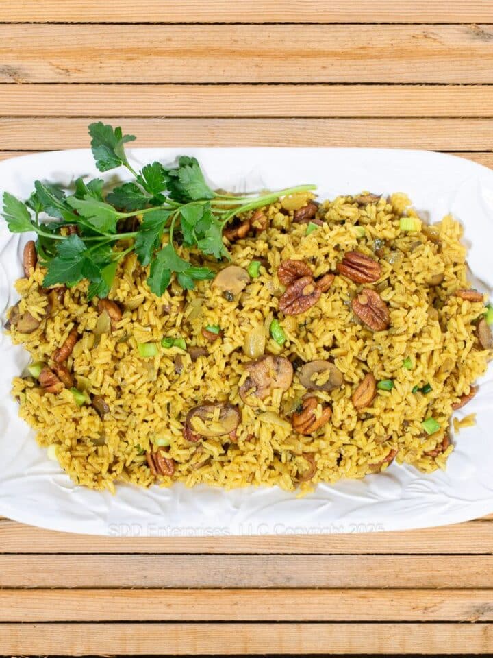 Pecan Rice on a white platter with parsley garnish.