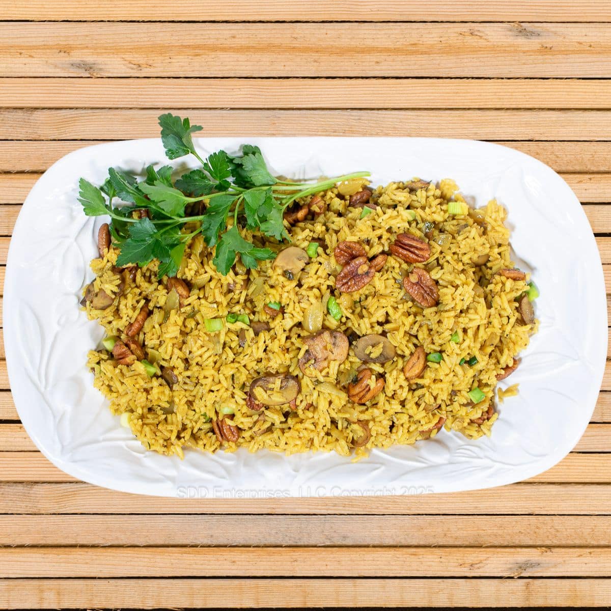 Pecan Rice on a white platter with parsley garnish.