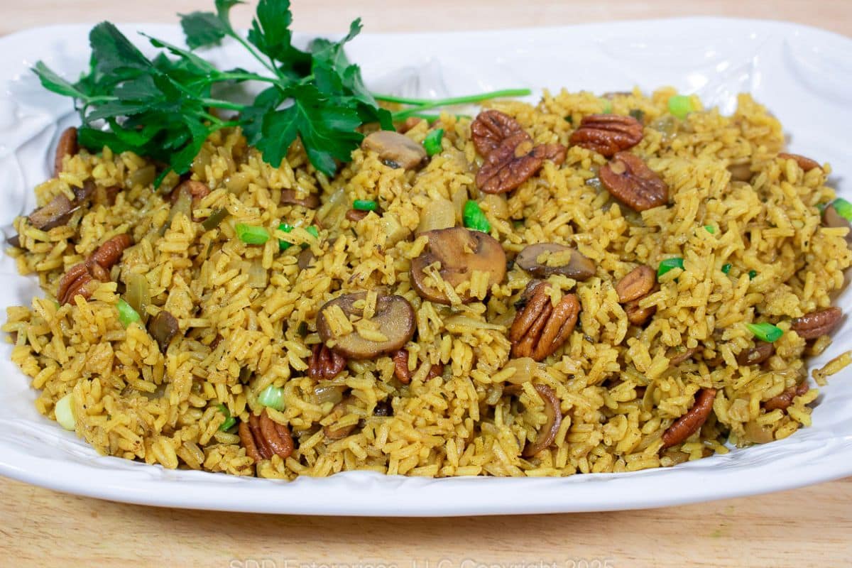 Pecan Rice on a white platter with parsley garnish.