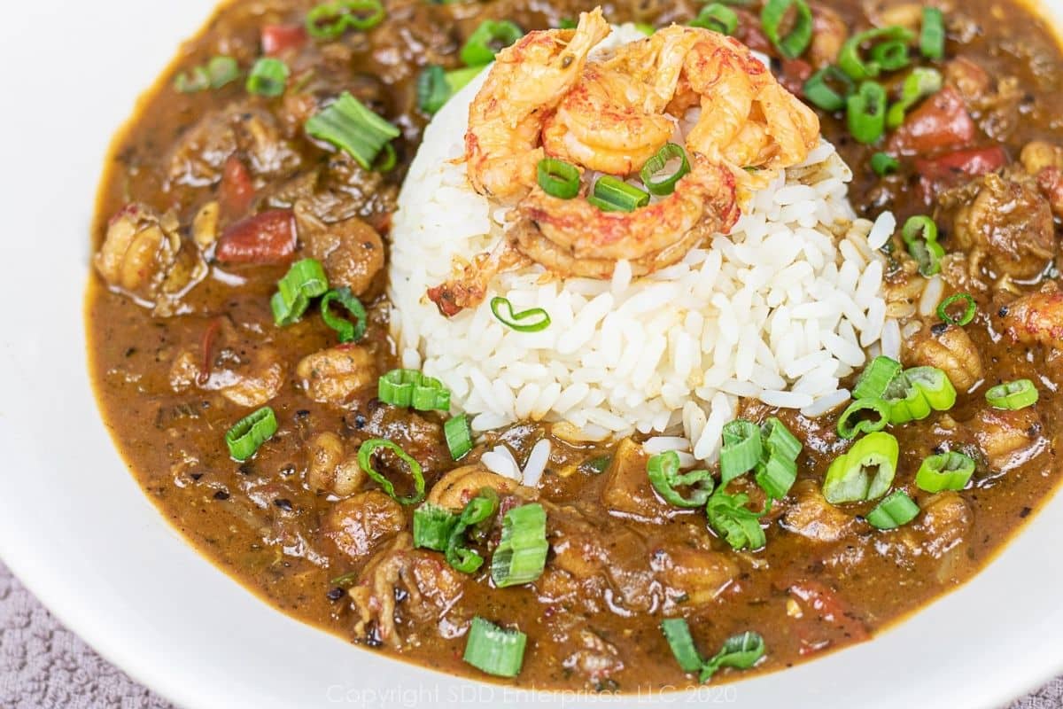 A bowl of Crawfish Etouffee with rice and garnish.
