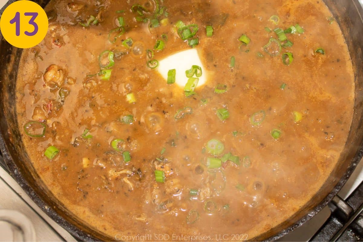 Finishing an etouffee with butter in a Dutch oven.
