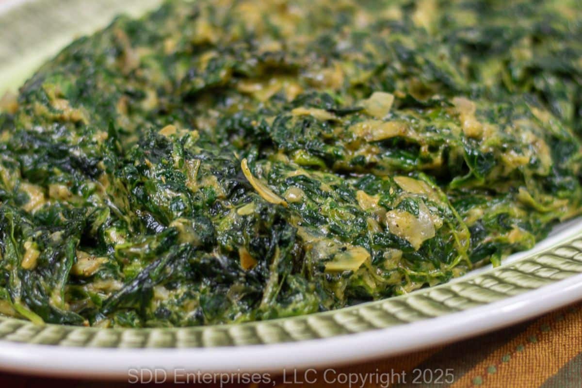 Creamed Spinach with Artichoke on a green and white serving platter.