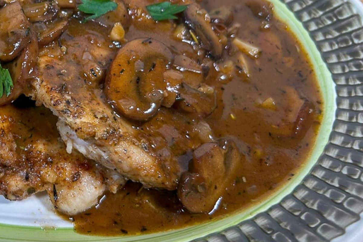 Mushroom Gravy over chicken breasts on a serving platter.