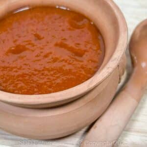 Peach BBQ Sauce in a small serving bowl with a ladle.