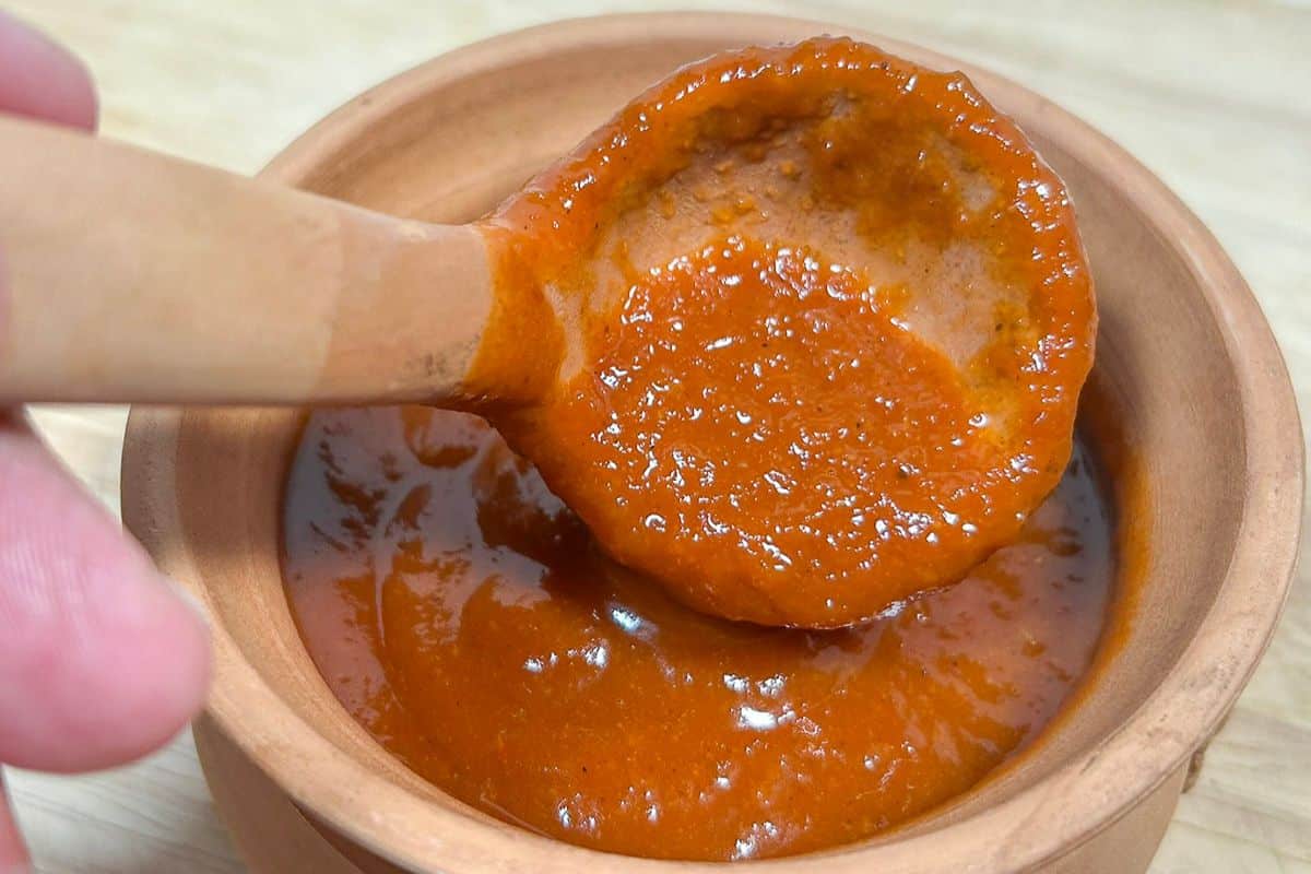 Peach BBQ Sauce in a serving bowl with a small ladle.
