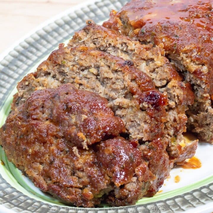 Sliced Meatloaf with Brown Glaze on a serving platter.