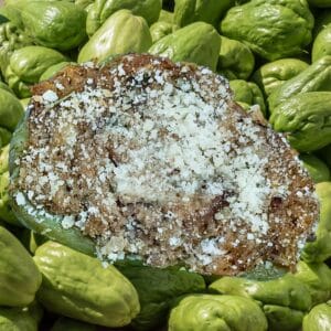 Shrimp and Crab Stuffed Mirliton overlaid on fresh mirliton (chayote).