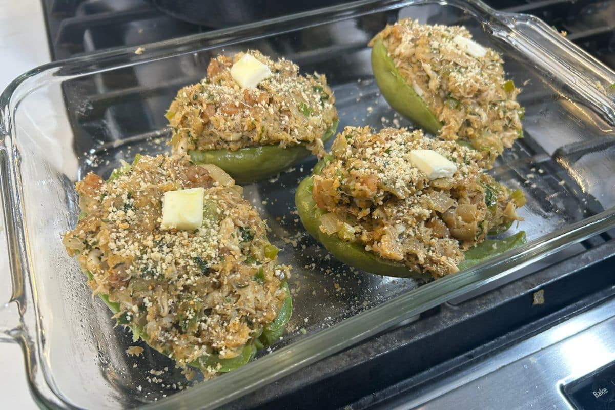 Shrimp and Crab Stuffed Mirliton topped with breadcrumbs and pats of butter ready for the oven.
