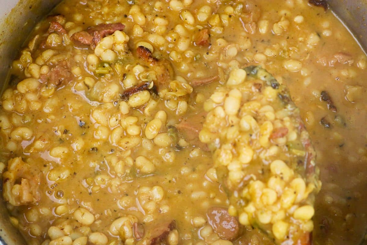 A Dutch oven full of White Beans and Ham.