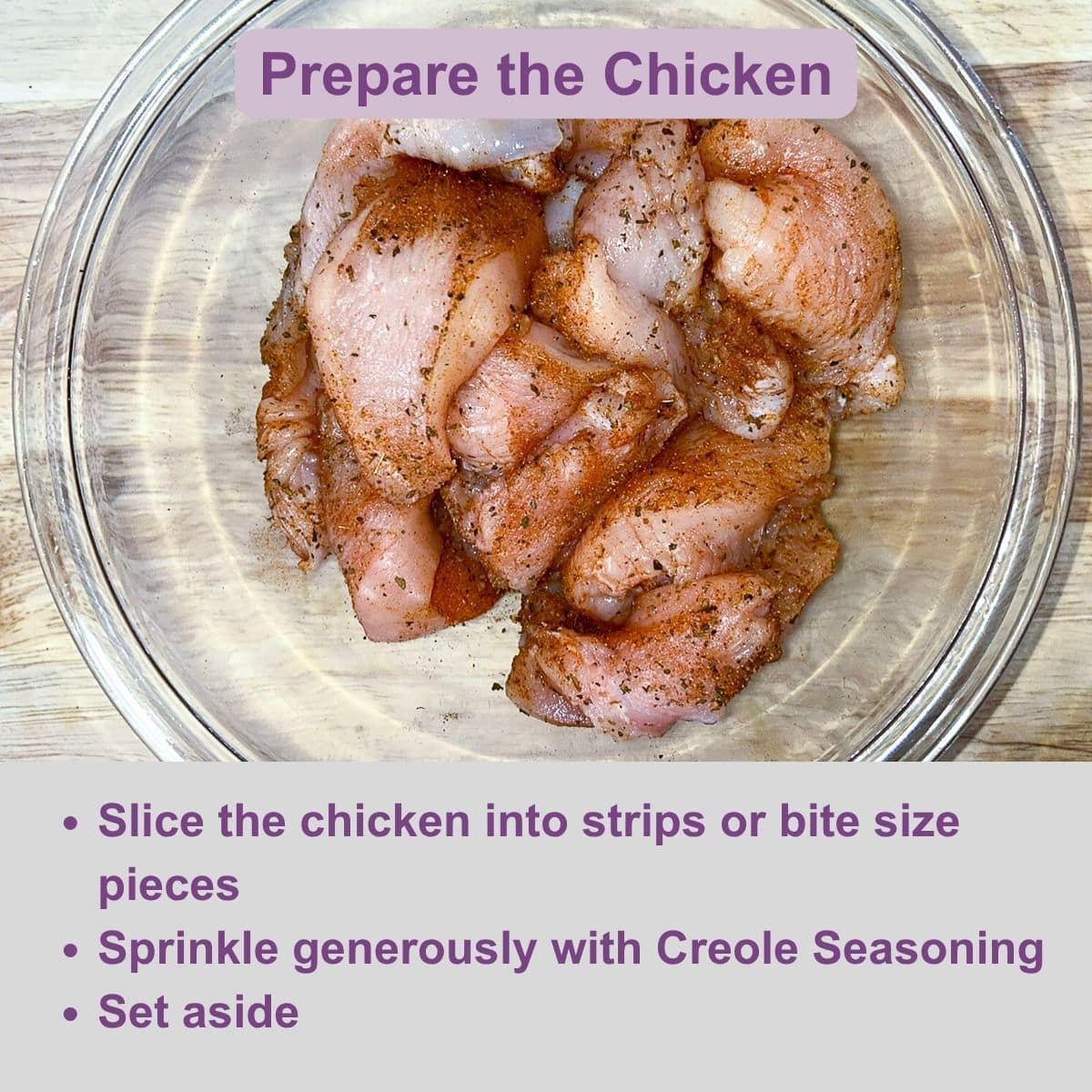 Chicken seasoned with Creole seasoning in a glass bowl.