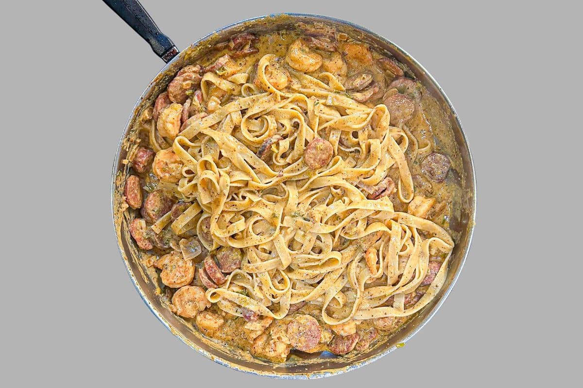 Shrimp and Andouille Pasta in Creole Mustard Sauce in a skillet.