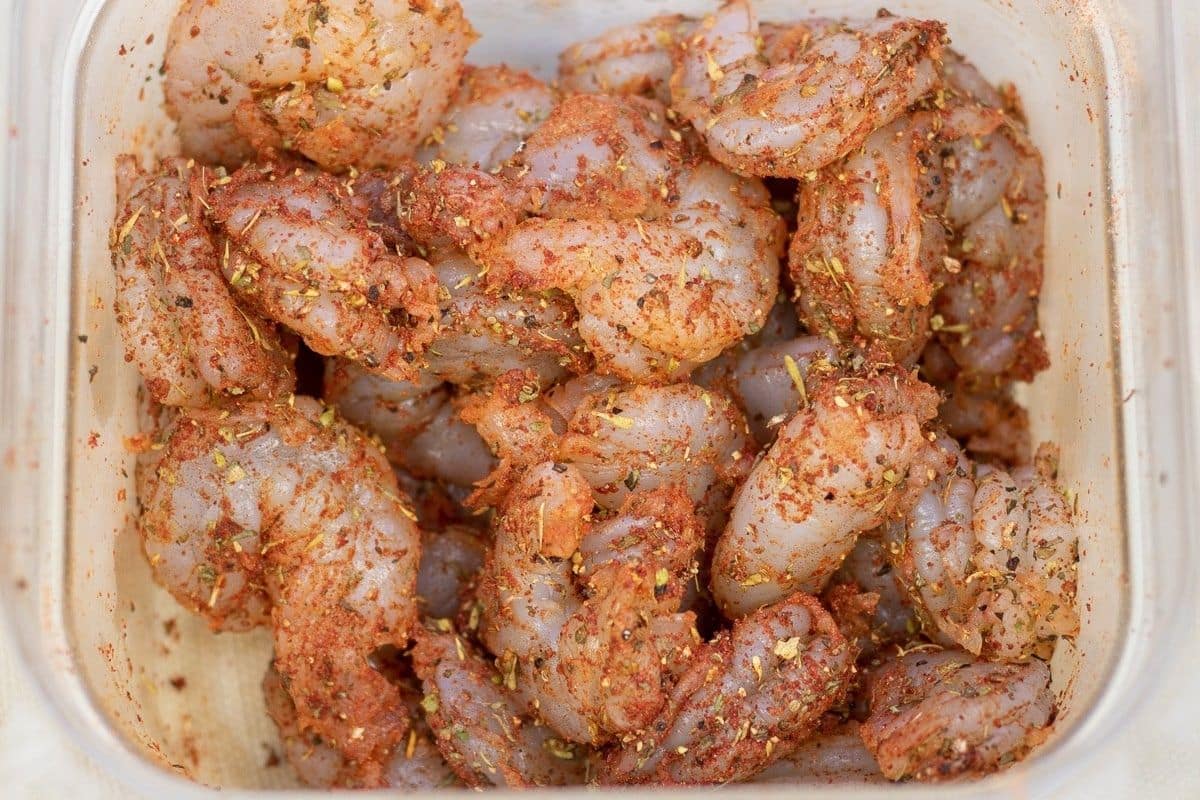 Seasoned raw shrimp in a prep bowl.