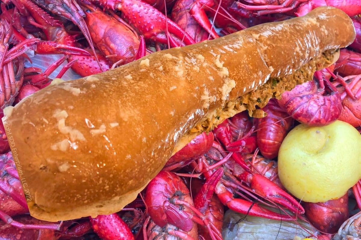 Close-up of cheesy crawfish bread filling inside French bread.