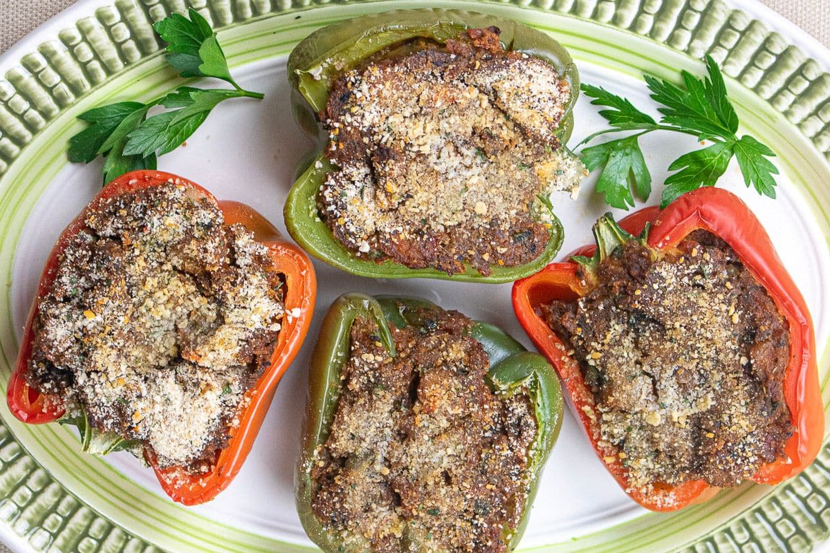 Baked stuffed crawfish peppers on a serving platter with garnish.