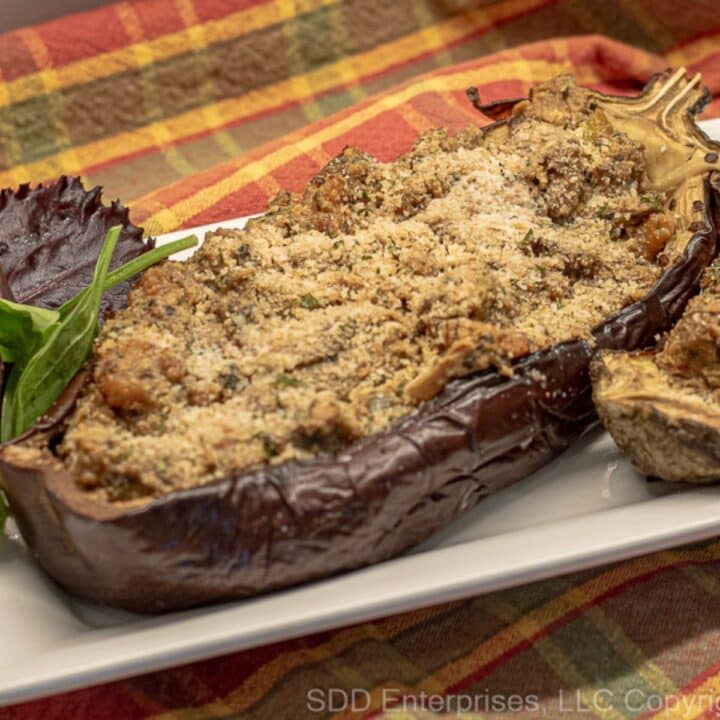 Eggplant Pirogue stuffed with shrimp on a serving platter with garnish.
