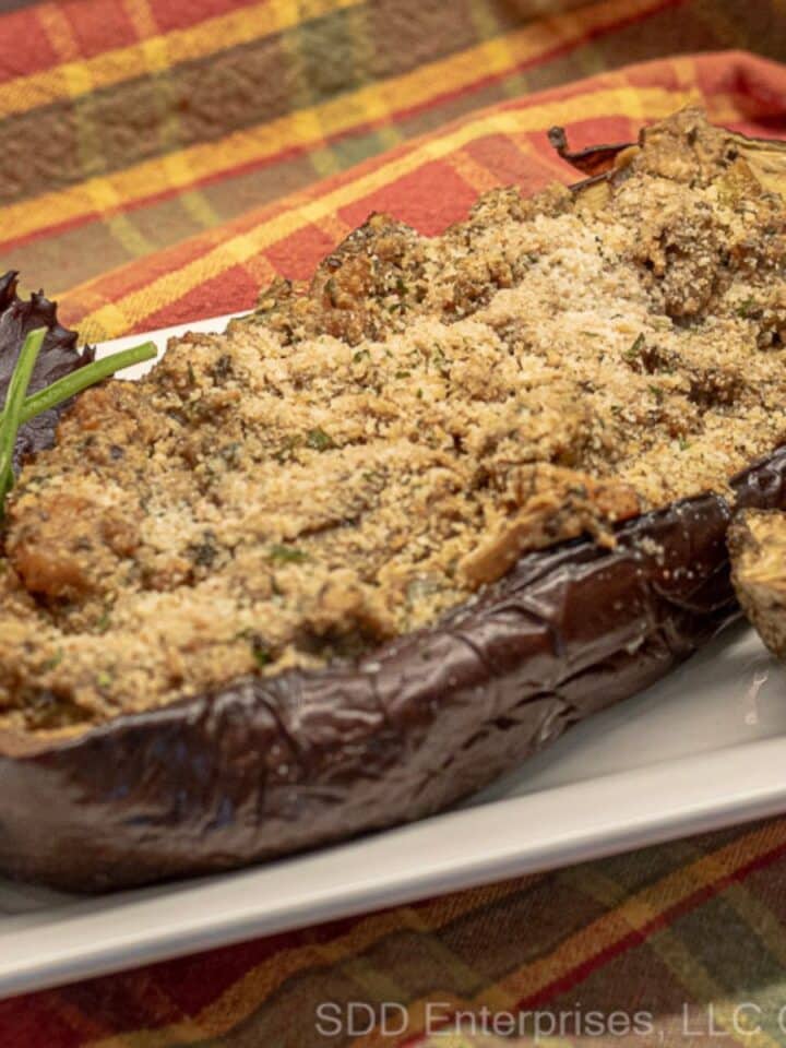 Eggplant Pirogue stuffed with shrimp on a serving platter with garnish.