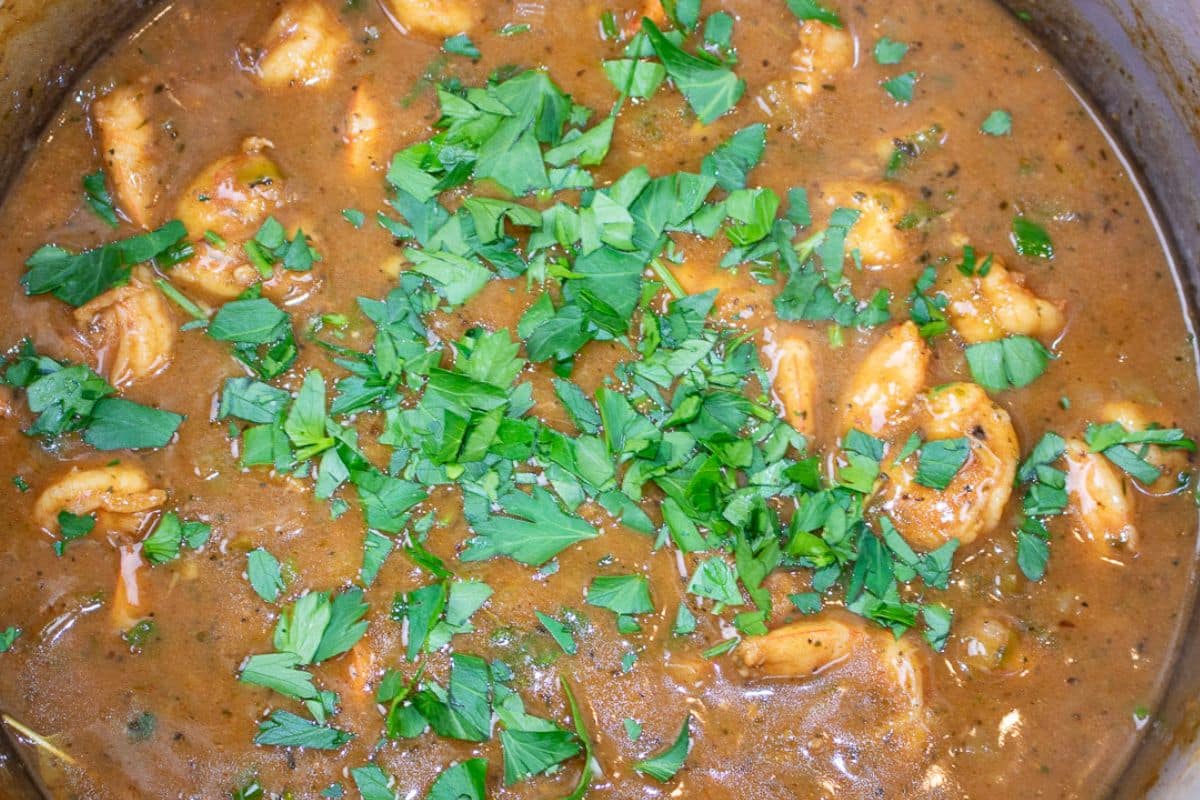 Shrimp Etouffee garnished with parsley in a Dutch oven.