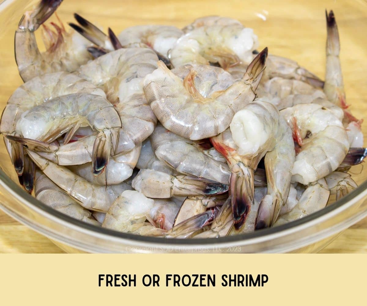 Shrimp in shells in a glass bowl.