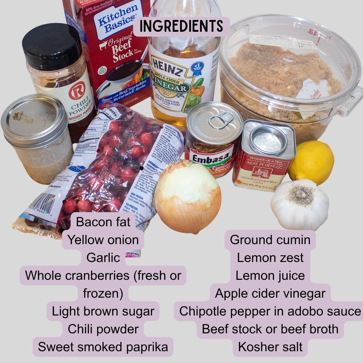 Ingredients for homemade Cranberry BBQ Sauce including cranberries, chipotle peppers, onions, garlic, bacon, brown sugar, spices, lemon, vinegar, and beef stock.