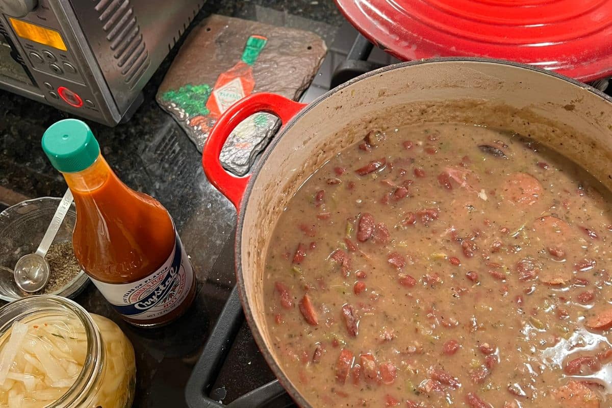 New Orleans Red Beans and Rice served over white rice with smoked sausage in a white bowl.