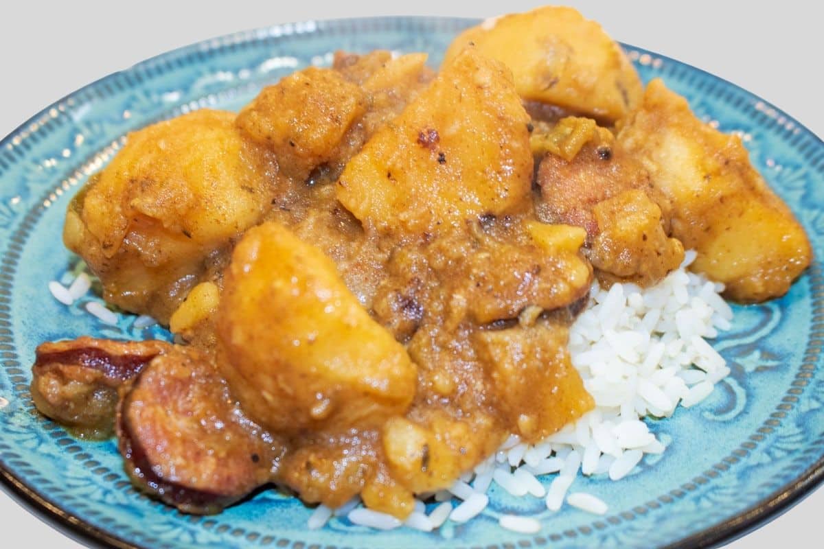 Cajun-smothered potatoes and browned smoked sausage in gravy, served over white rice.