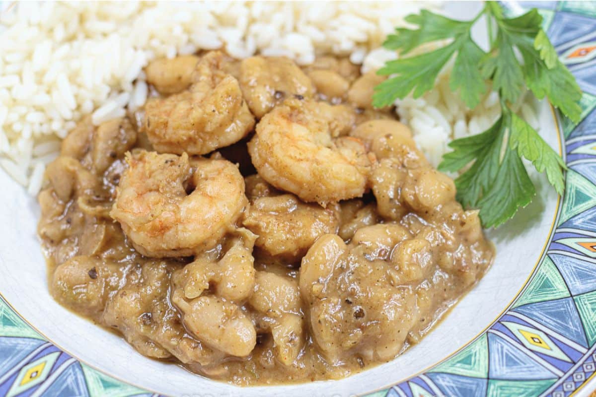 Close-up of creamy white beans and seasoned shrimp served with long-grain rice