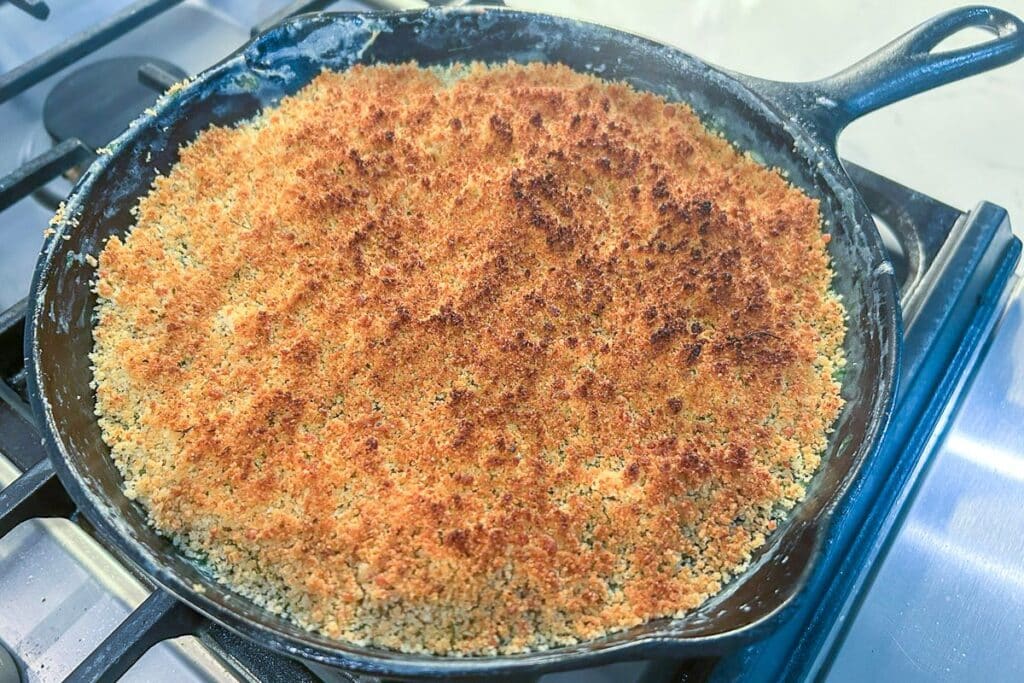 Creamed spinach finished and served in a cast-iron skillet.