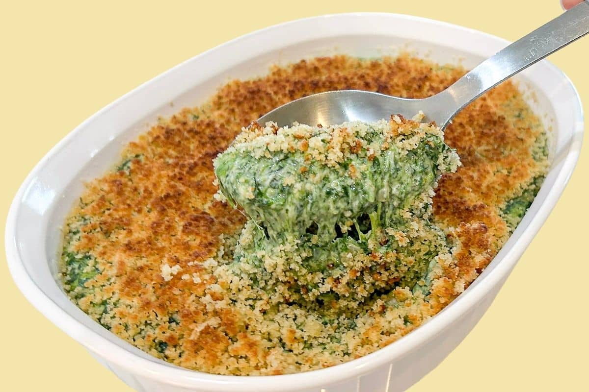 Creamed spinach with frozen spinach finished with a crisp golden Romano breadcrumb topping in a shallow baking dish.